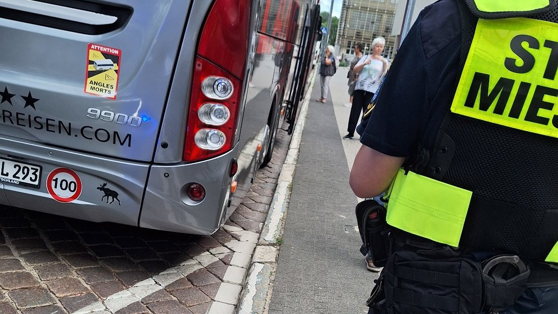 Na zdjęciu widać strażnika miejskiego, który rozmawia z kierowcą autokaru - sprawca uszkodzenia znaku na alejach Marcinkowskiego
