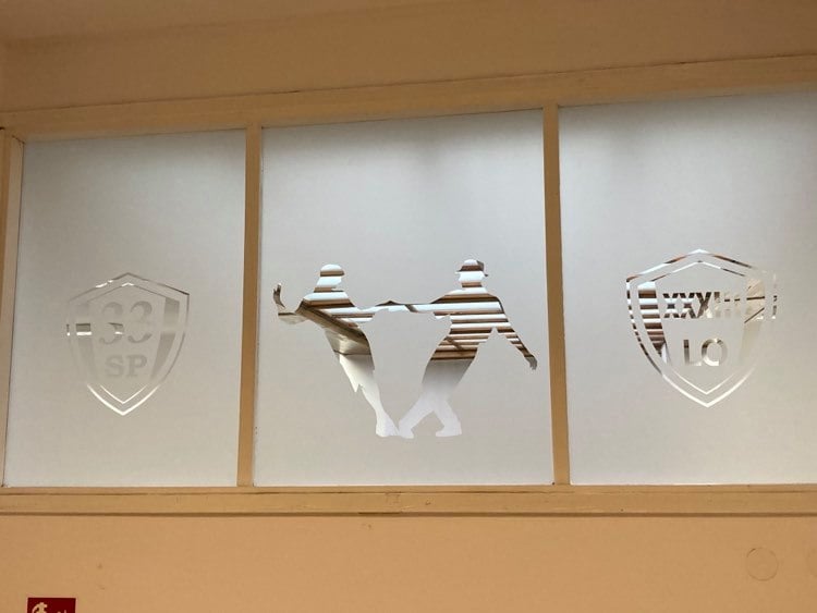 zdjęcie przedstawia mleczną szybę z wyciętymi: logo SP ## oraz LO 33, a także z dwójką tancerzy - grafika artykułu