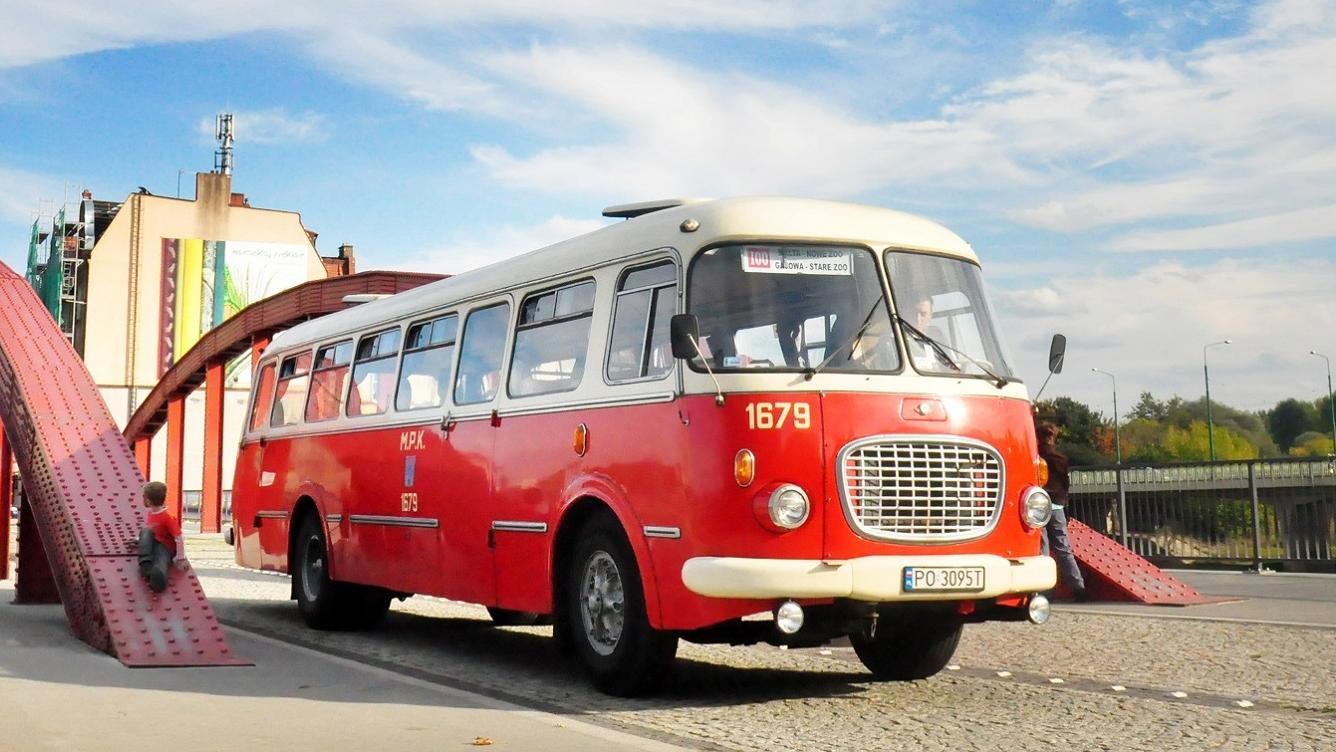 Zdjęcie przedstawia czerwony zabytkowy autobus, jadący po moście Jordana. - grafika artykułu