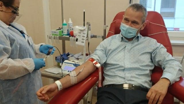 Wnętrze gabinetu. Na czerwonym fotelu zabiegowym siedzi Jędrzej Solarski, zastępca prezydenta Poznania, obok pielęgniarka pobiera od niego krew