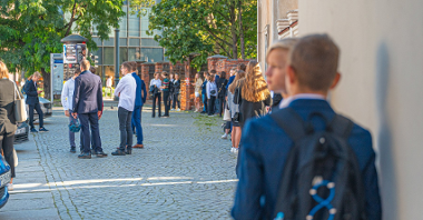 Zdjęcie przedstawia uczniów przed szkołą.