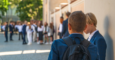 Zdjęcie przedstawia uczniów przed szkołą.