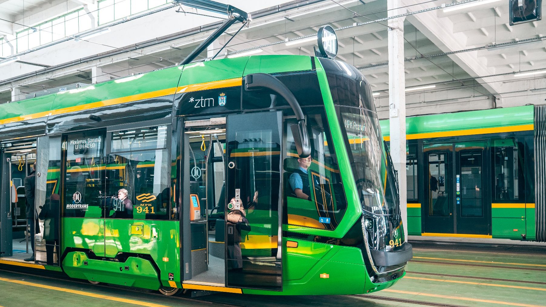 Na zdjęciu zielony tramwaj w hali zajezdni