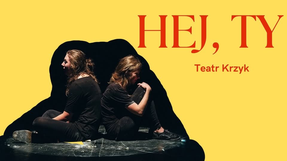 Plakat promujący spektakl Teatru Krzyk pod tytułem "Hej, Ty". Na środku scena w czerni, dwóch ludzi siedzi plecami do siebie, ubranych na czarno, z rozmazanymi twarzami. Tło w jaskrawym żółtym kolorze.
