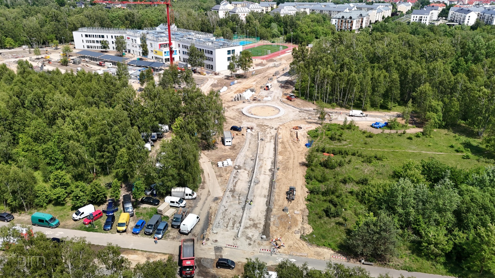 Na zdjęciu budowa drogi widziana z lotu ptaka, w tle widać szkołę - grafika artykułu