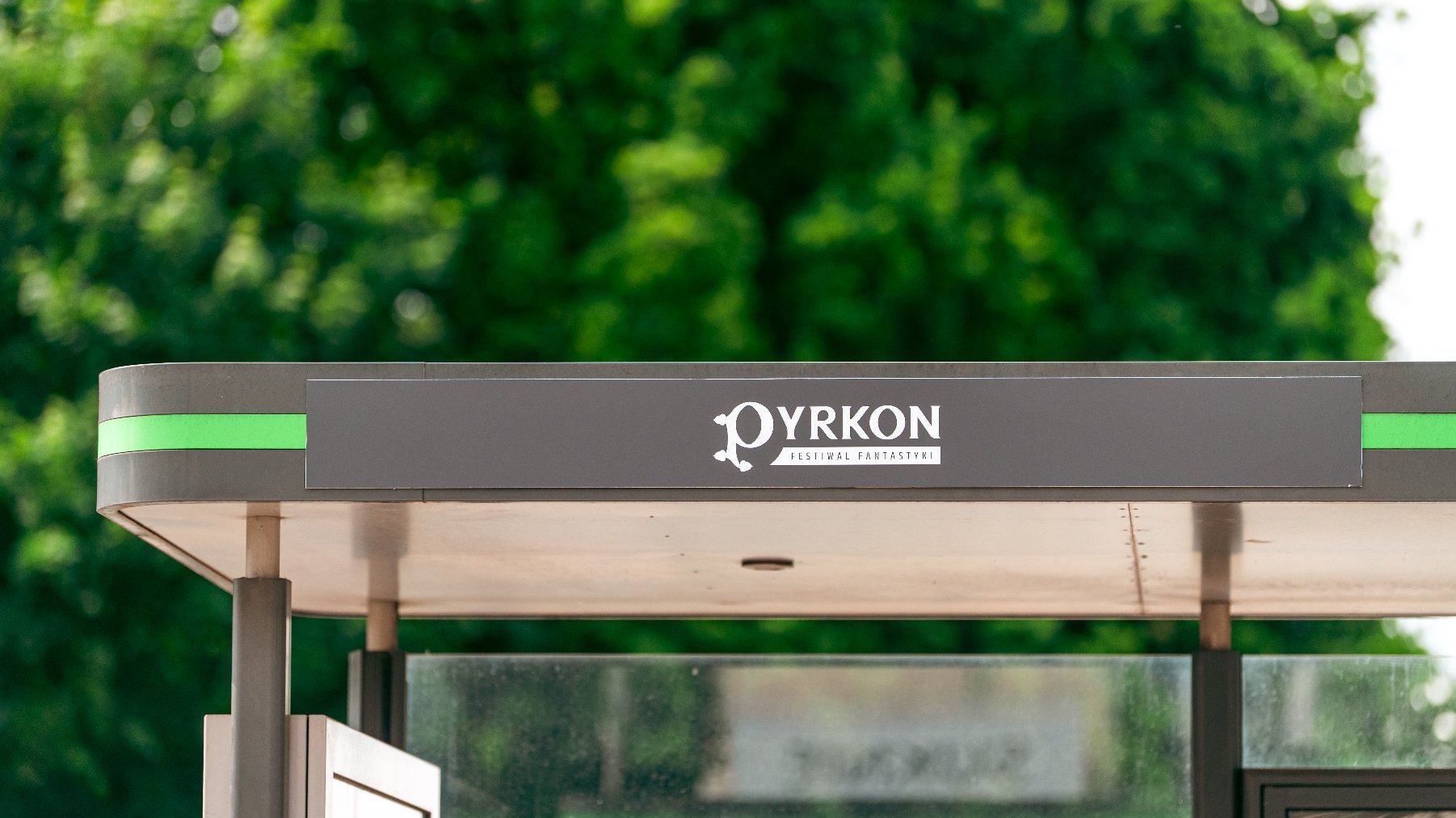 Zdjęcie przedstawia przystanek tramwajowy z napisem Pyrkon.