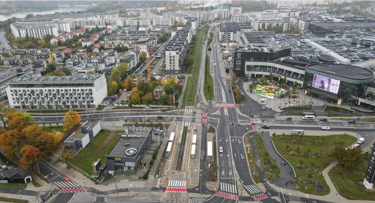Panorama Poznania. Zdjęcie przedstawia skrzyżowanie z torami tramwajowymi biegnącymi przez środek. Po prawej stronie widać duże centrum handlowe Posnania, a w tle osiedla mieszkaniowe. - grafika artykułu