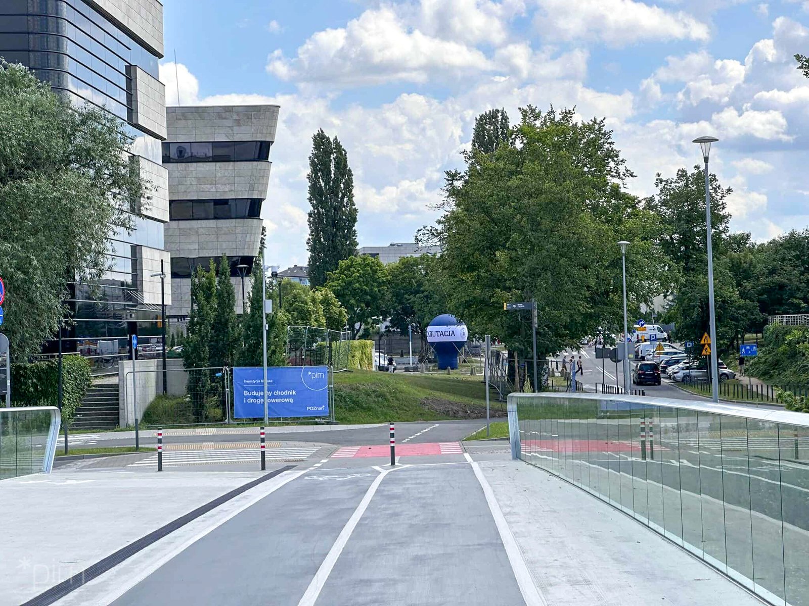 Na zdjęciu droga rowerowa, w tle budynki politechniki - grafika artykułu