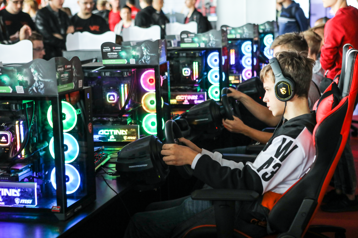 Głównie młodzi ludzie siedzący prze komputerami gamingowymi - grafika artykułu