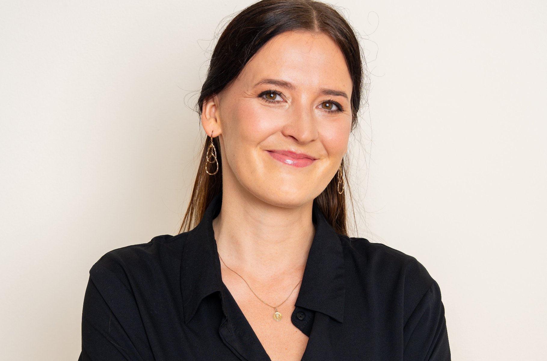 Na zdjęciu uśmiechnięta dziewczyna o ciemnych włosach pozująca do obiektywu - grafika artykułu