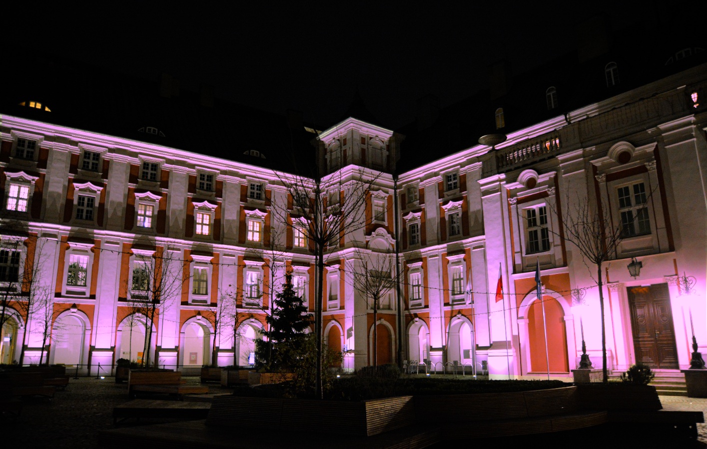 Na zdjeciu budynek urzędu miasta podświetlony na fioletowo - grafika artykułu