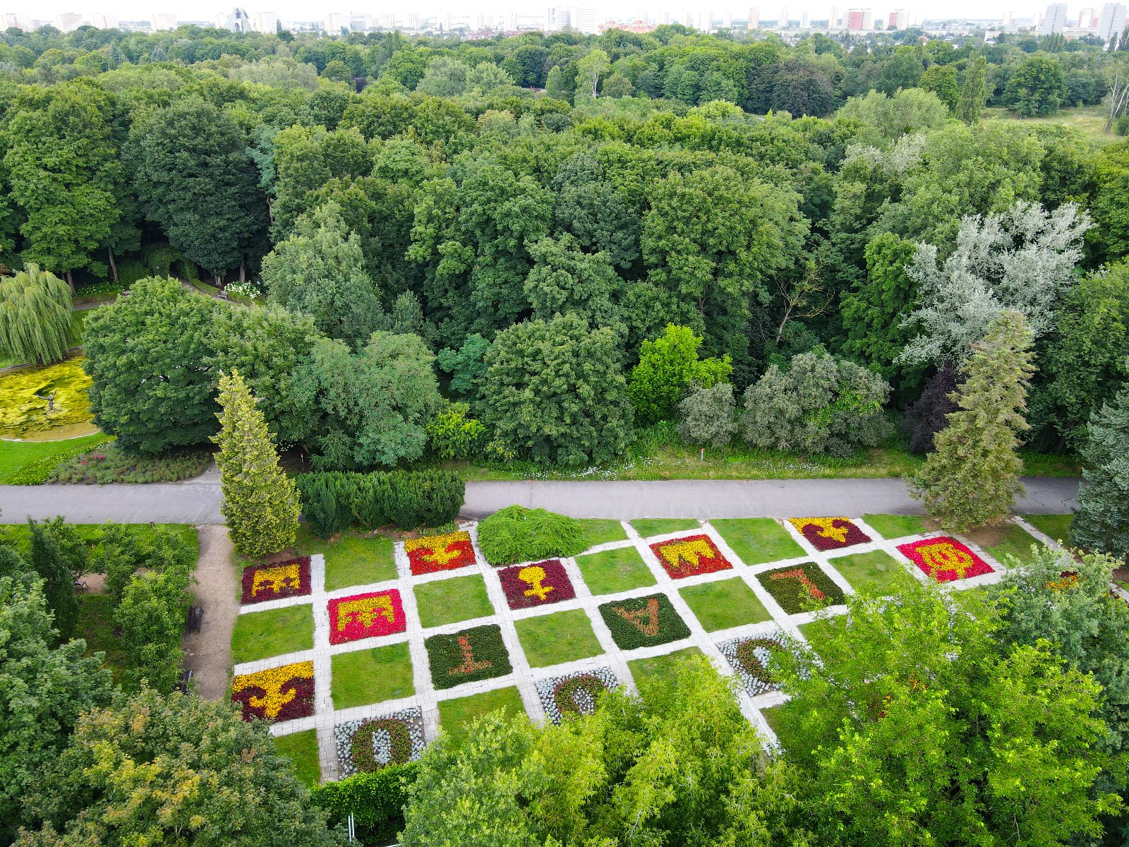 Zdjęcie przedstawia instalację kwiatową ułożoną w kształcie królewskich insygni - korony i berła oraz napis 1000 lat. Zdjęcie zrobiono z lotu ptaka. - grafika artykułu