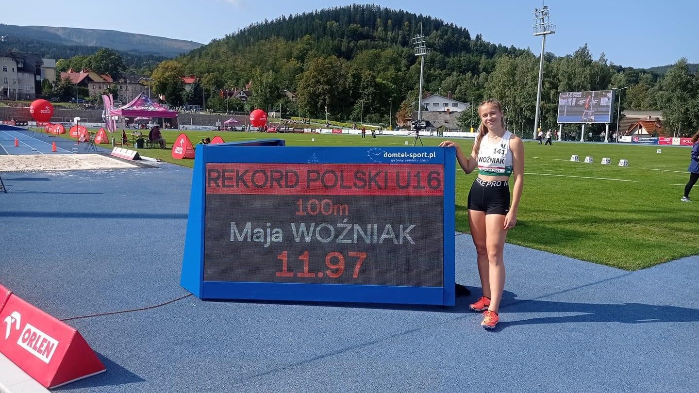 zawodniczka na tle tablicy wyników z napisem rekod polski U16