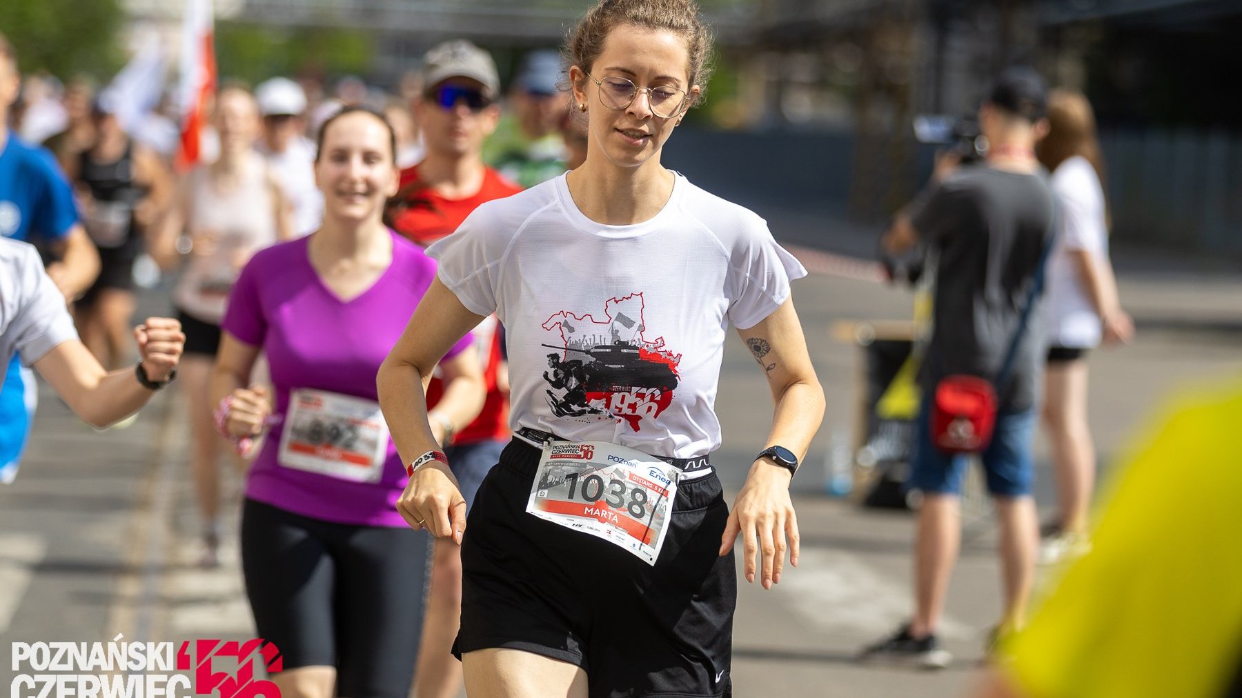 Na zdjęciu widać na pierwszym planie uczestniczkę biegu na trasie Biegu Czerwca, w tle więcej uczestników