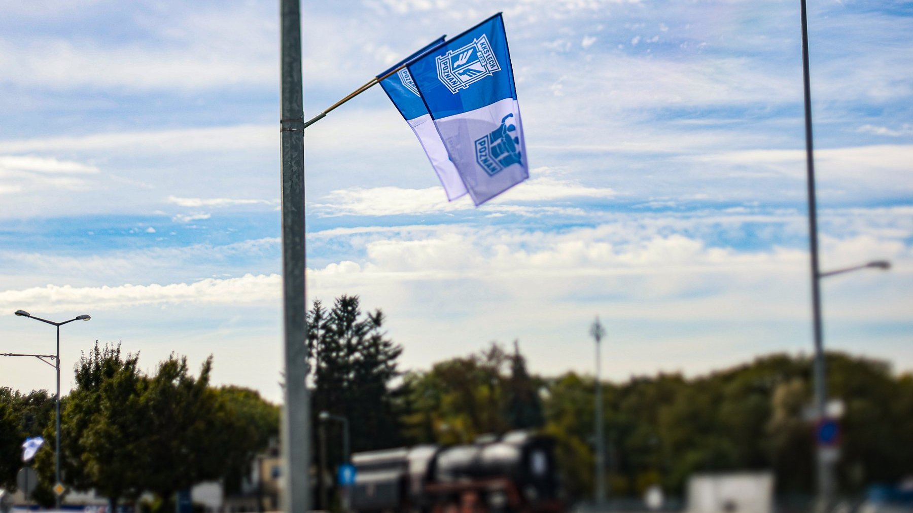 Flagi Lecha na latarniach. W tle lokomotywa