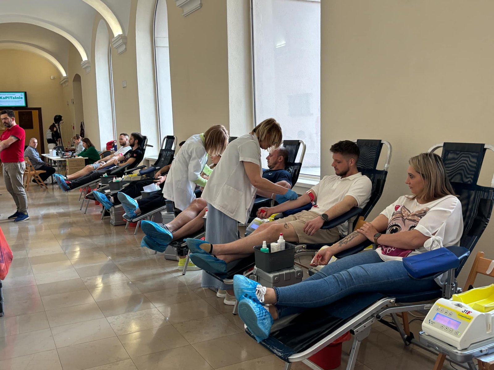 W korytarzu Urzędu miasta Poznania kilka osób leży na łóżkach i oddaje honorowo krew - grafika artykułu
