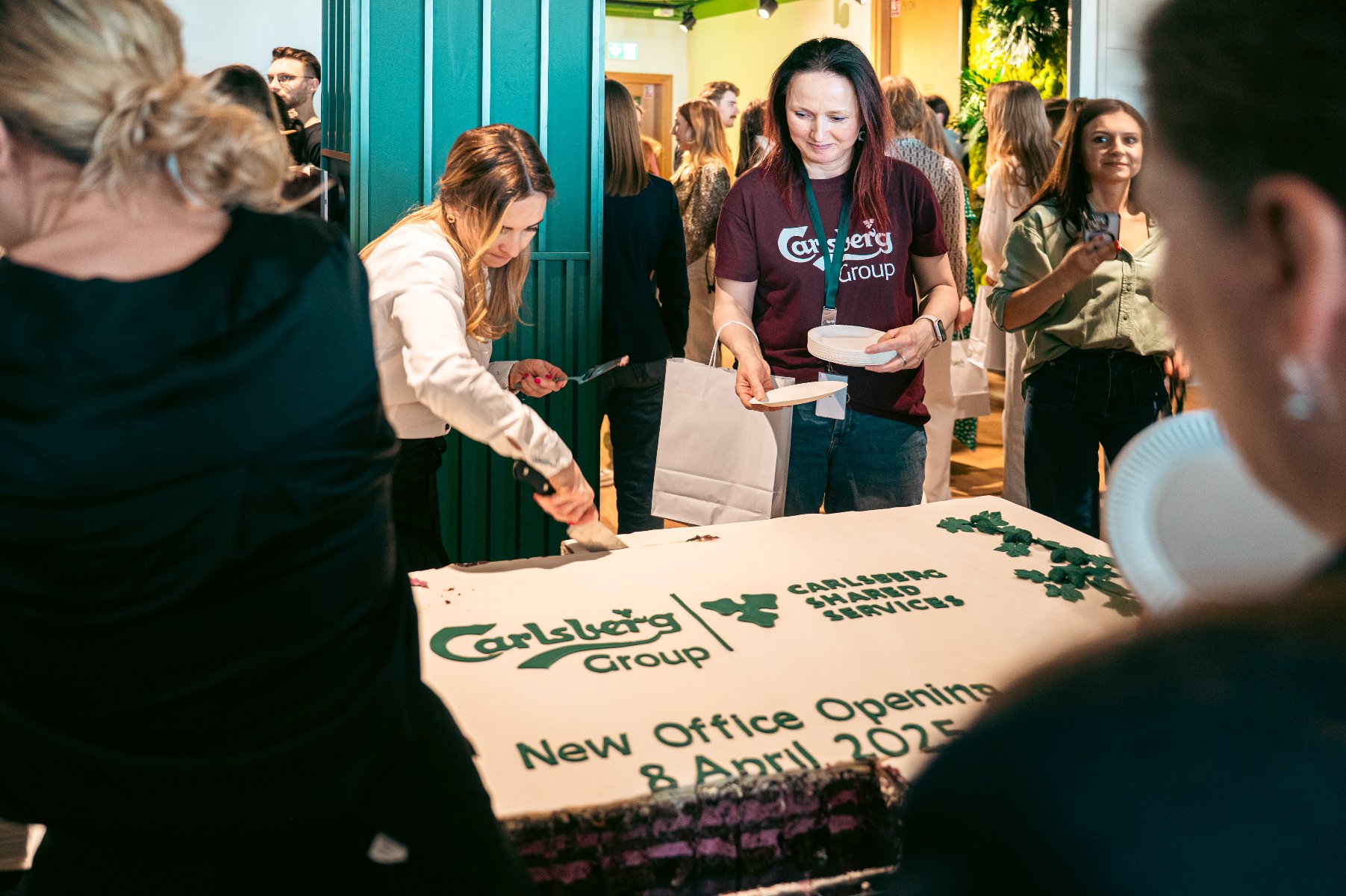 Pracownicy kroją tort na oficjalnym otwarciu biura Carlsberg - grafika artykułu