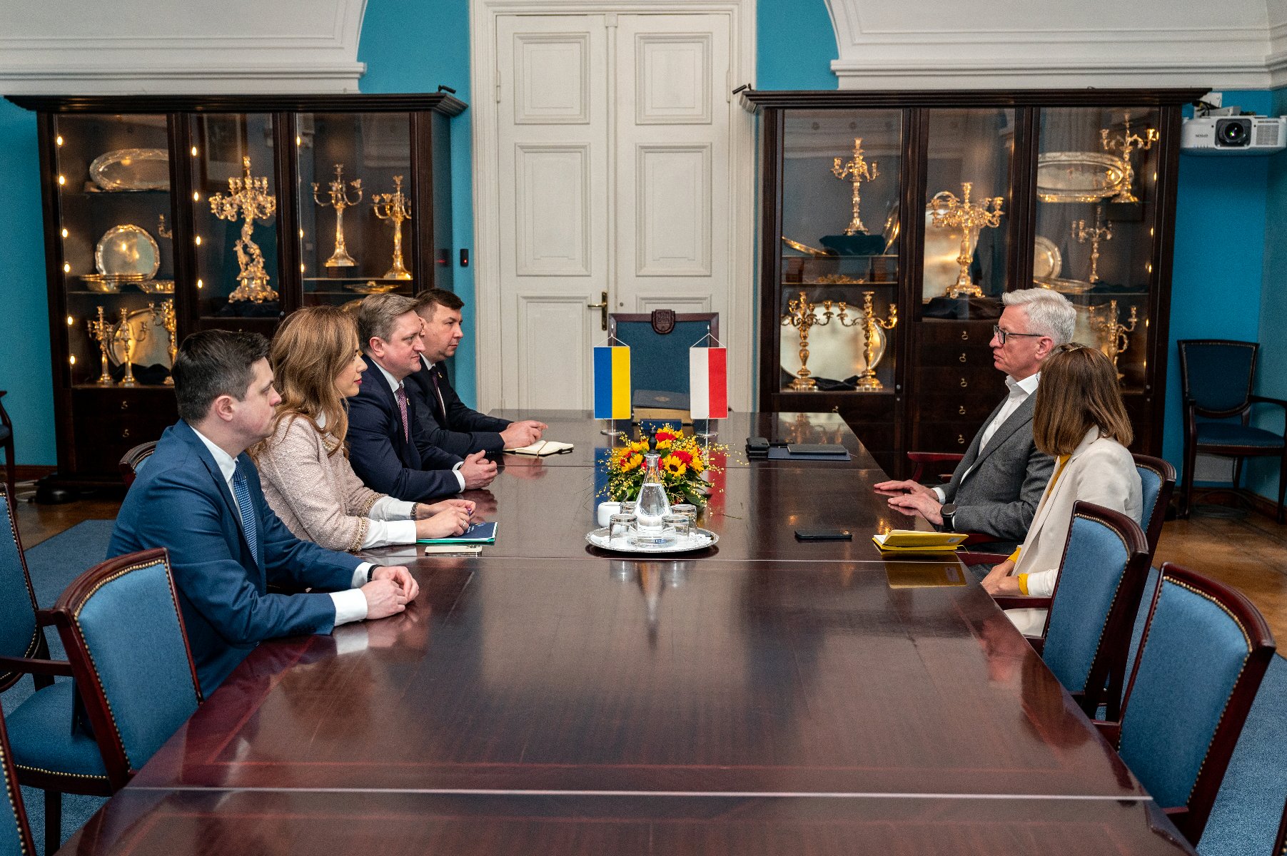 Zdjęcie przedstawia grupę ludzi siedzących przy stole, wśród nich m.in. Jacek Jaśkowiak, prezydent Poznania oraz Wasyl Zwarycz, ambasador Ukirany w Polsce. - grafika artykułu