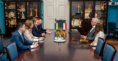 Zdjęcie przedstawia grupę ludzi siedzących przy stole, wśród nich m.in. Jacek Jaśkowiak, prezydent Poznania oraz Wasyl Zwarycz, ambasador Ukirany w Polsce.