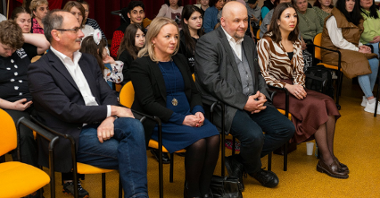Grupa osób siedzących na krzesłach podczas spotkania z ambasadorem Ukrainy.