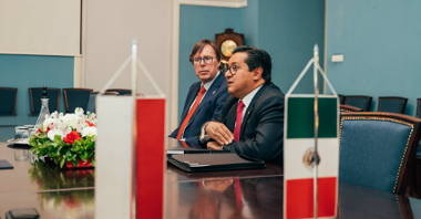 Na zdjęciu ambasador Meksyku przy stole, na pierwszym planie flagi