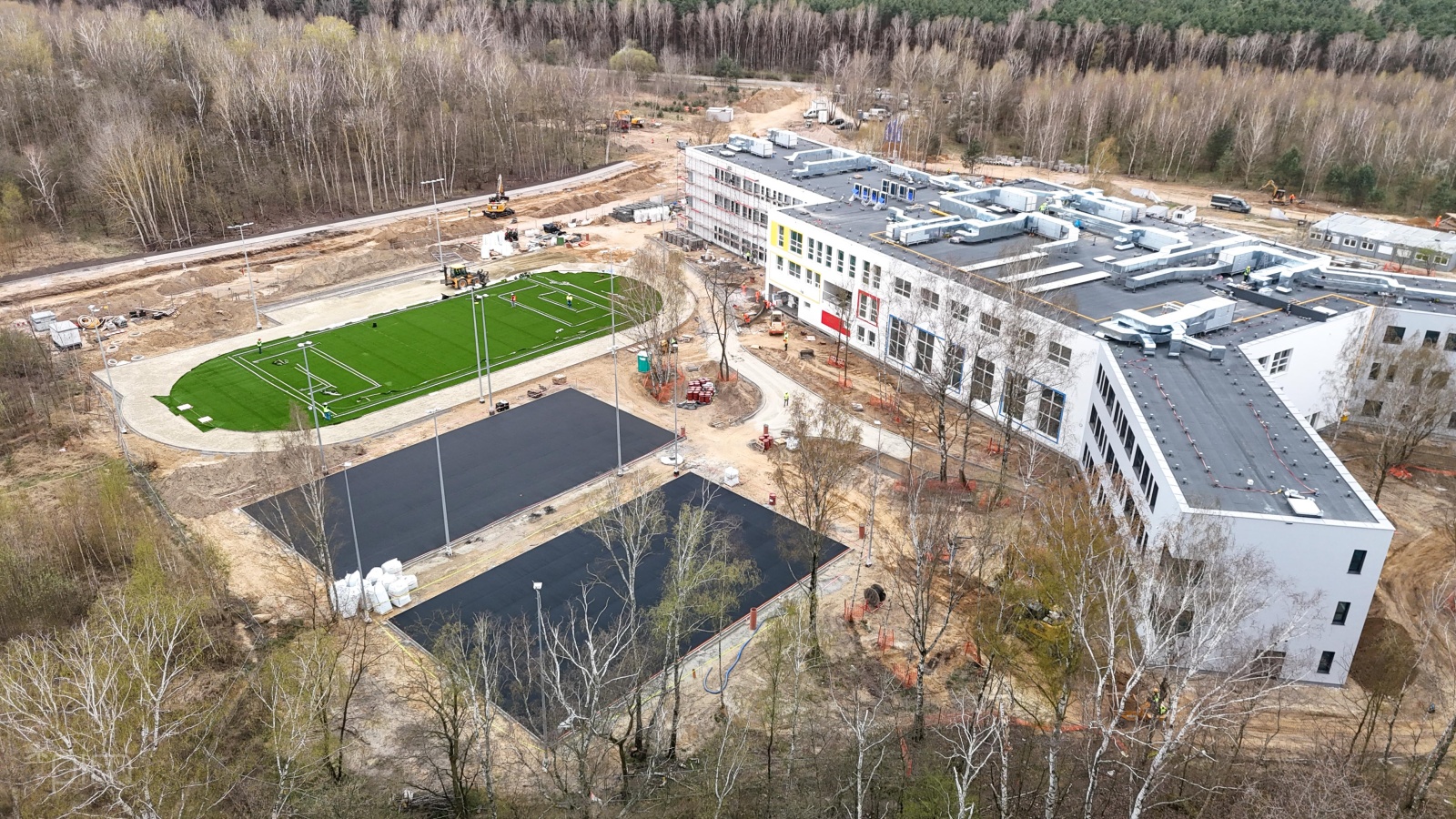 Galeria zdjęć z postępu prac przy budowie szkoły na Strzeszynie i dróg wokół niej - widok z powietrza na okolice szkoły i boisk sportowych - grafika artykułu