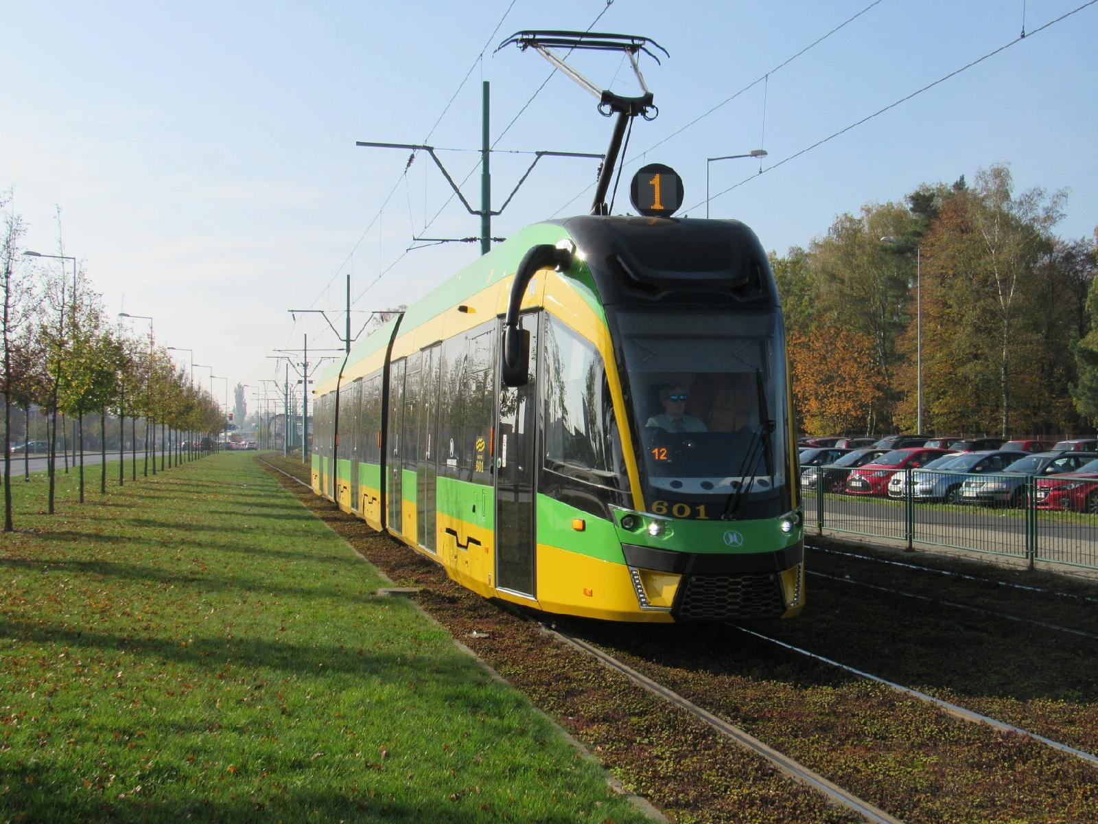 Żółto-zielony tramwaj linii nr 1 jadący z Junikowa, obok trawiasty pas zieleni - grafika artykułu
