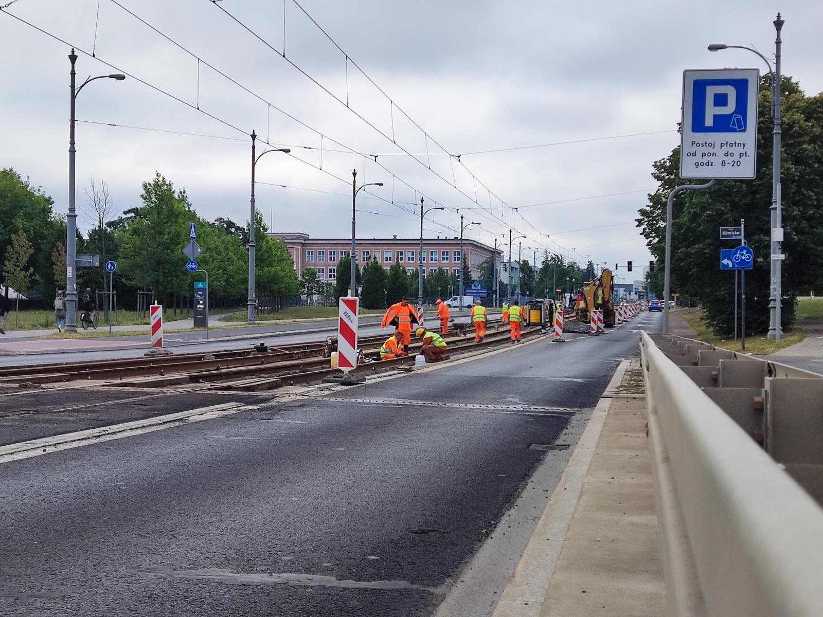 Zdjęcie prac przy remoncie torowiska przy ul. Kórnickiej, rovbotnicy pracuja na torach przy zwężonej jezdni - grafika artykułu