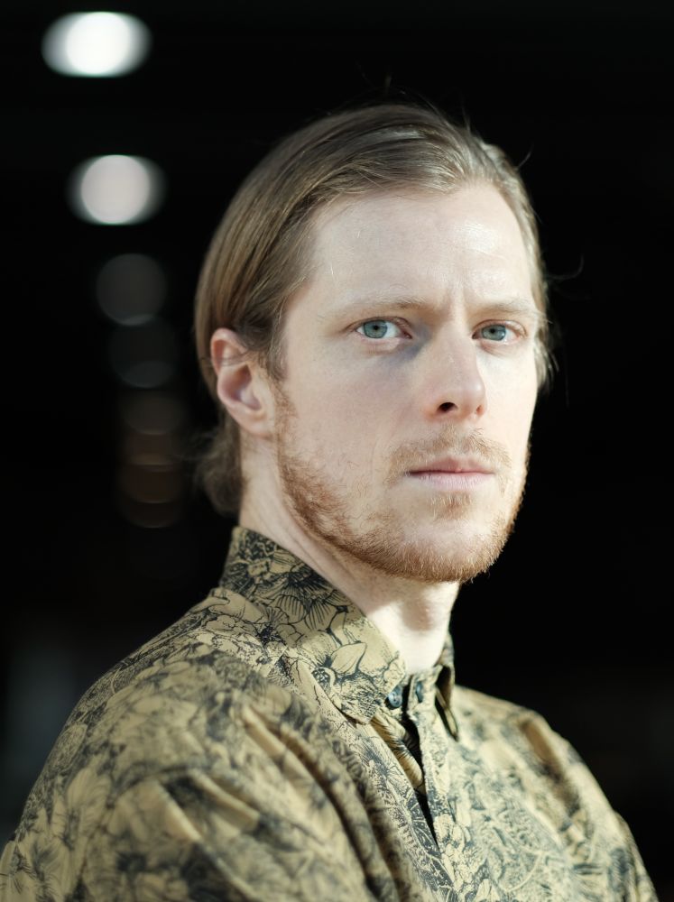 Młody mężczyzna w zielonej koszuli w kwiatowy wzór. - grafika artykułu