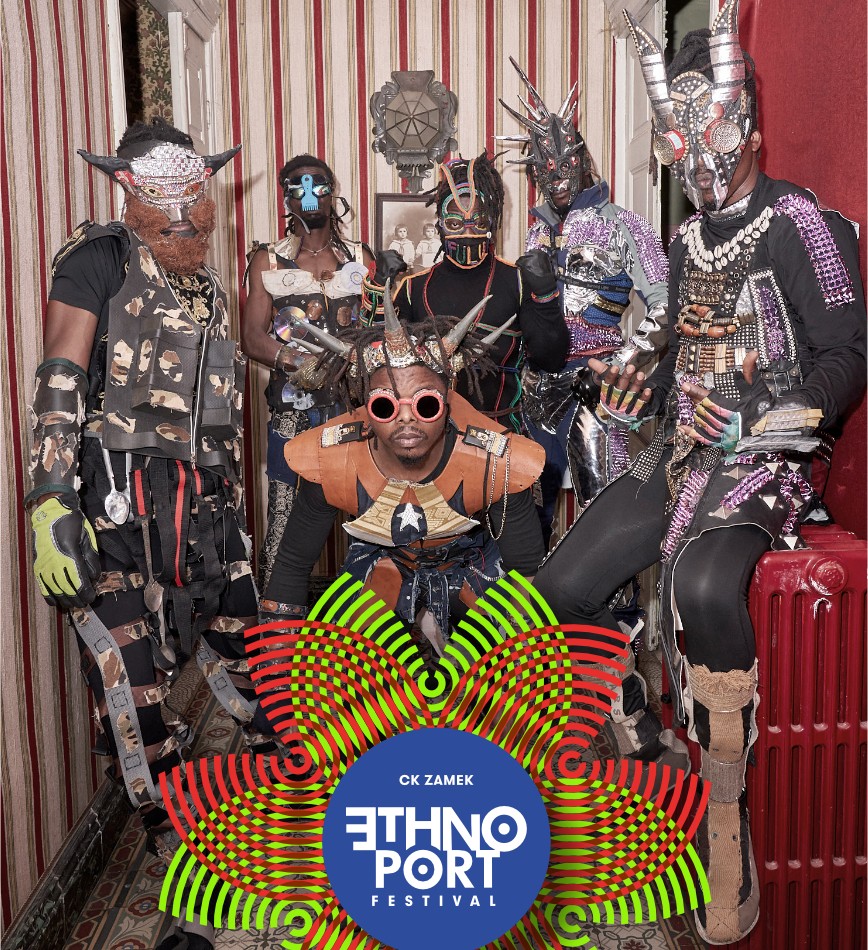 Szóstka czarnoskórych mężczyzn w fantazyjnych kostiumach, maskach i opaskach/rogach zrobionych jakby ze śmieci. - grafika artykułu