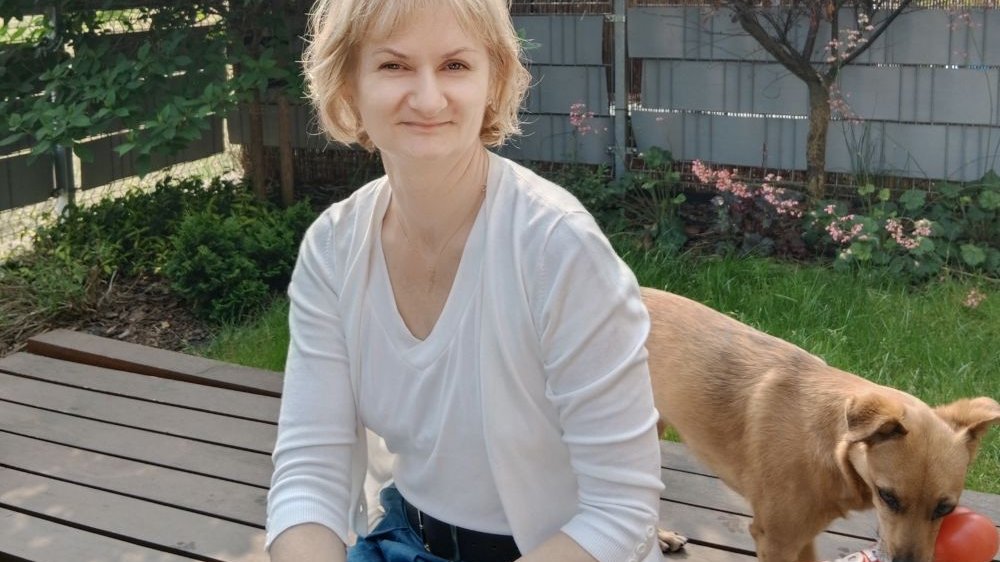 Kobieta z psem w ogrodzie.