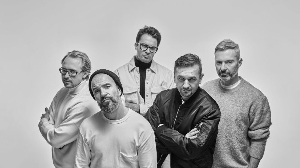 Czarno-białe zdjęcie grupowe zespołu.