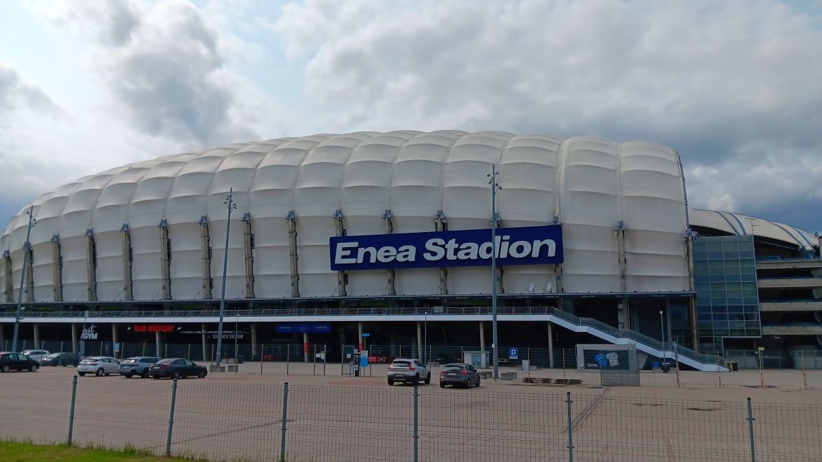 widok na kopułę stadionu z zewnątrz, przed stadionem parkuje kilka samochodów