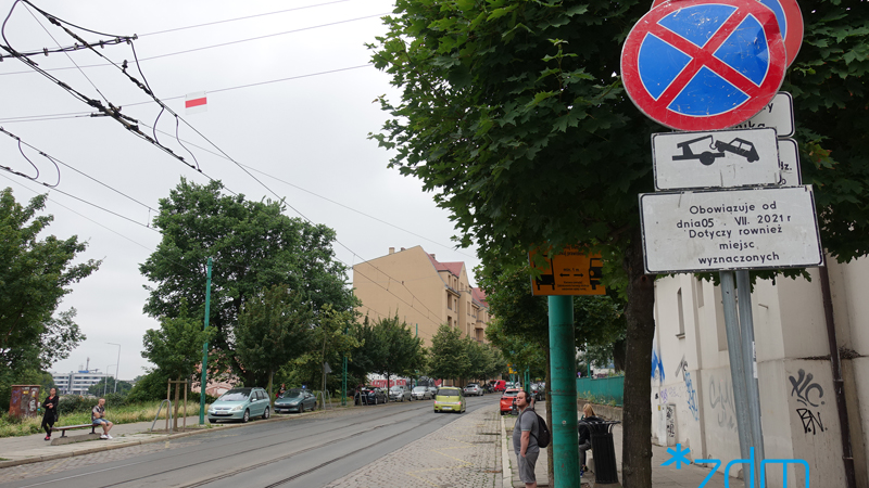 Ulica Górna Wilda przed wprowadzeniem zmian. Po lewej zaparkowane samochody, na środku tory tramwajowe, po prawej jedzie samochód. Na chodniku pieszy.