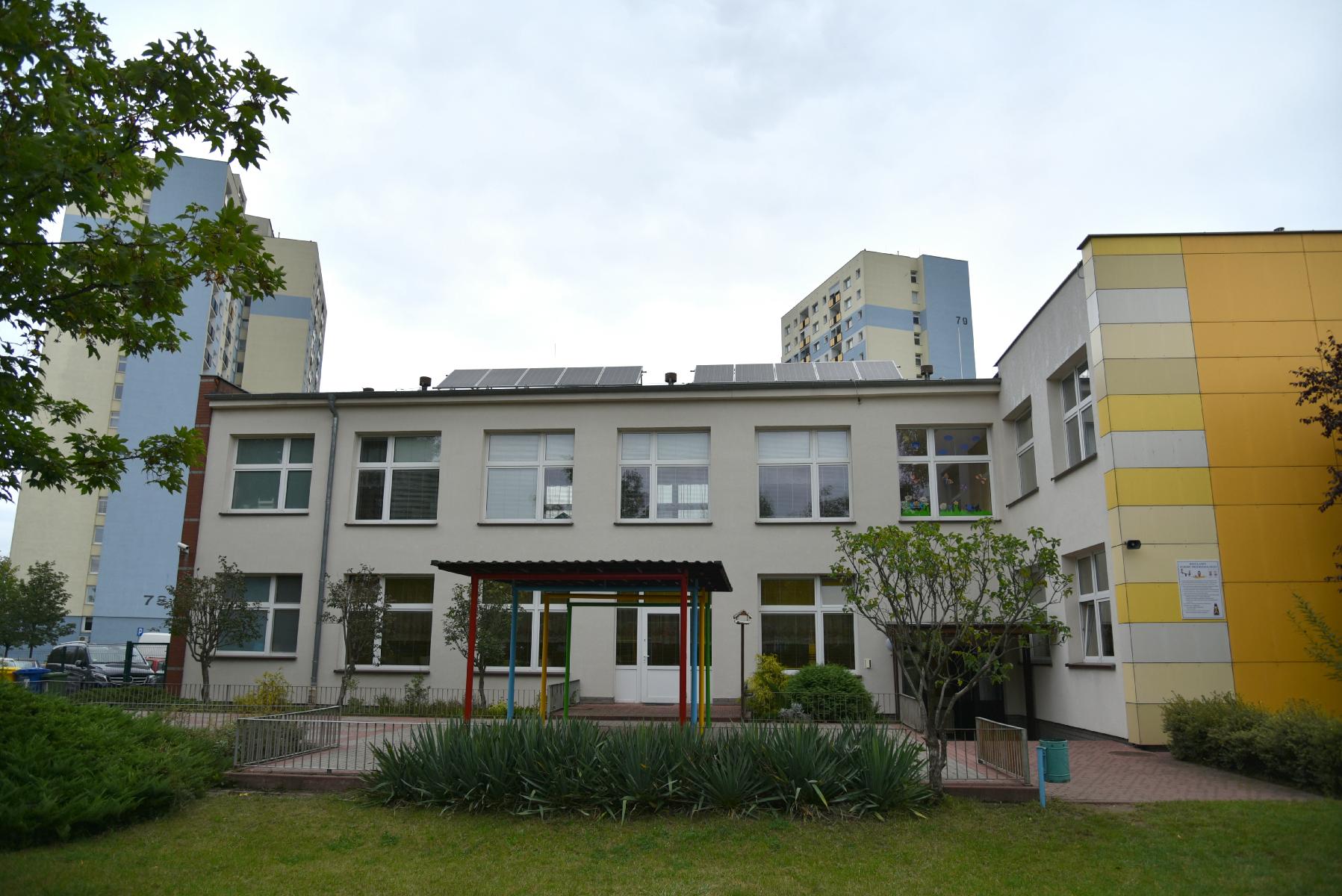 Zdjęcie przedstawia budynek przedszkola. Na dachu widać panele fotowoltaiczne. - grafika artykułu