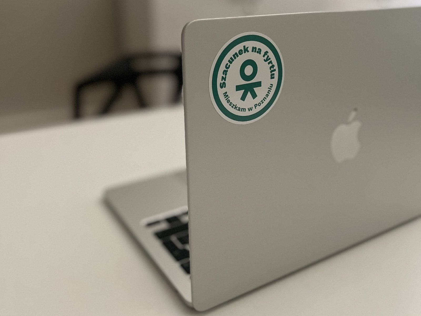 Srebrny laptop, na którym przyklejono naklejkę Szacunek na fyrtlu. Mieszkam w Poznaniu. - grafika artykułu