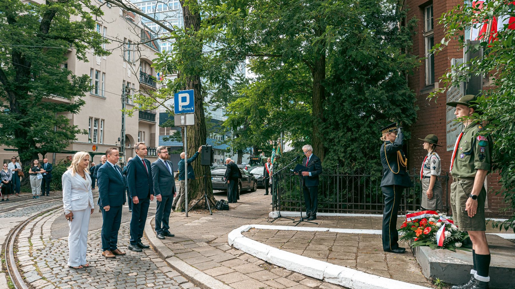 Na zdjeciu delegacja miejska składająca kwiaty przed tablicą na terenie zajezdni tramwajowej