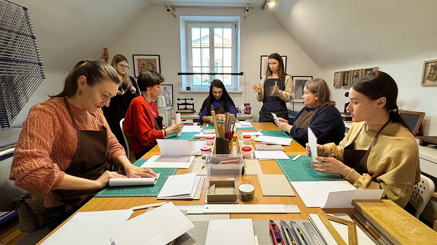 Na zdjęciu widoczni są uczestnicy warsztatów introligatorskich