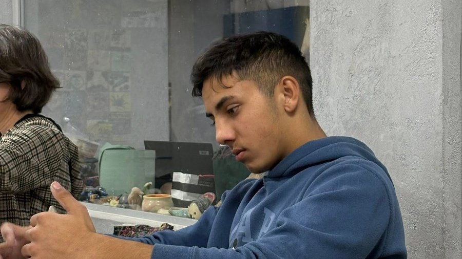 Studenci pracują nad gliną w pracowni ceramiki, tworząc różnorodne dzieła artystyczne.