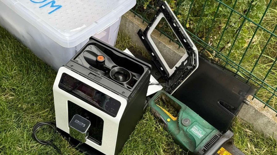 Na zdjęciu widać zużyty sprzęt elektryczny, m.in. stary ekspres ciśnieniowy do kawy i elektryczną piłę łańcuchową