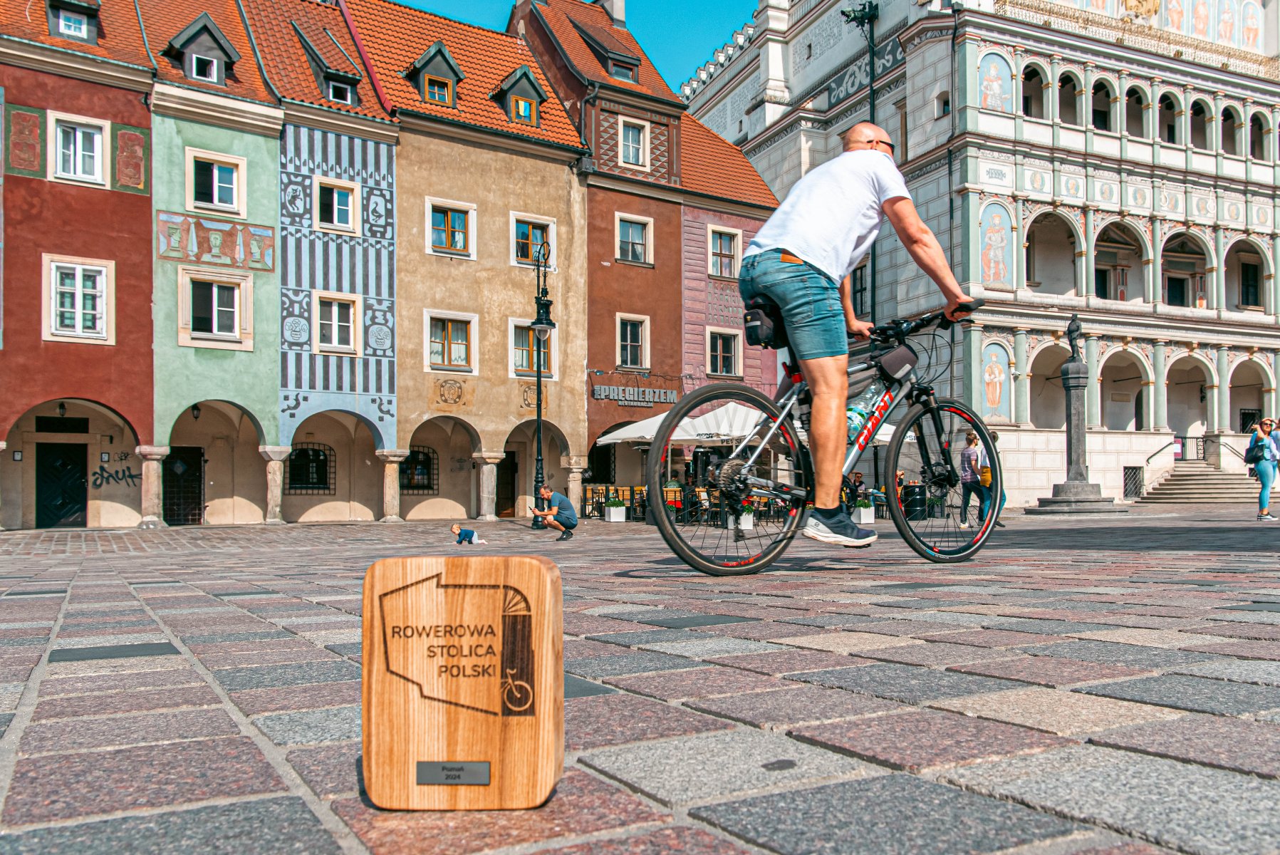 W zeszłym roku Poznań był drugim miastem z największą liczbą wykręconych kilometrów. W tej edycji też jest na 2. miejscu Rowerzysta na Starym Rynku. W tle Ratusz i domki budnicze