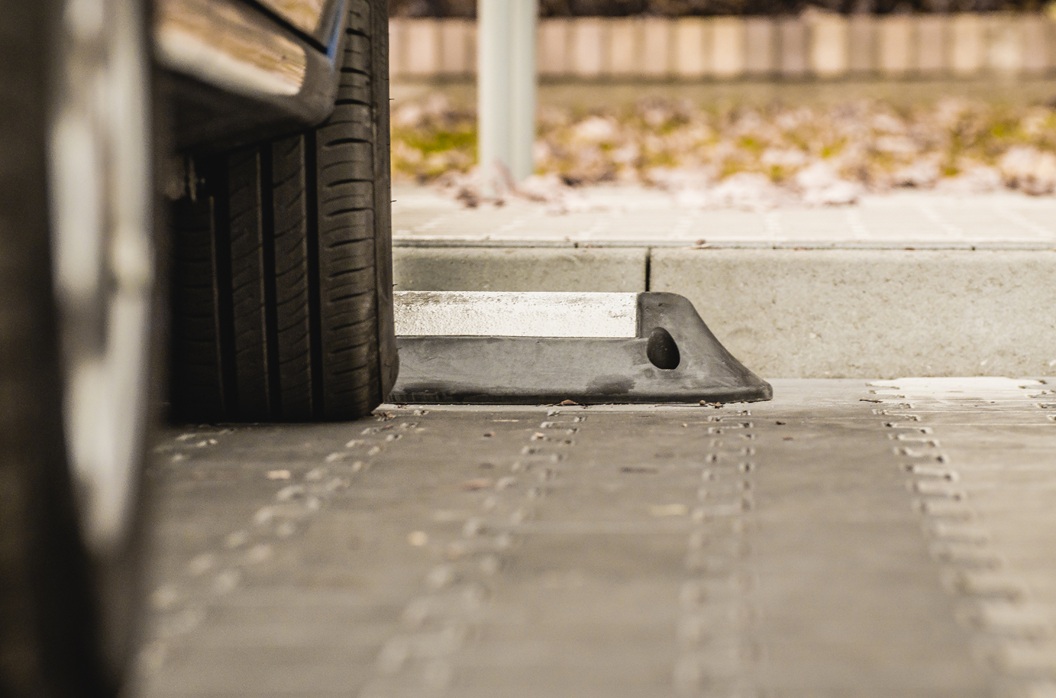 samochód na parkingu, widoczne tylko opony i dolna część auta