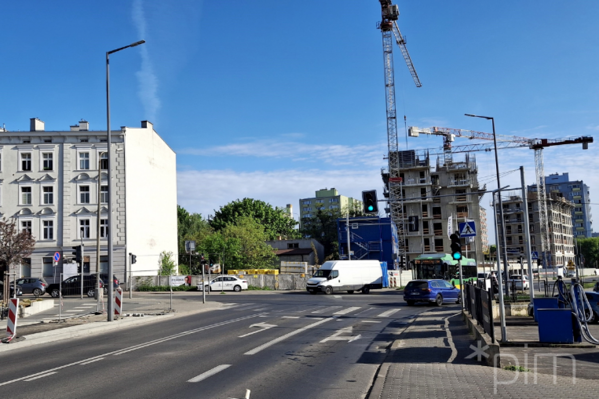 Od poniedziałku, 5 maja, wykonawca rozpoczyna kolejny etap inwestycji - przebudowę ciągów pieszo-rowerowych na skrzyżowaniu ul. Dmowskiego i Krauthofera, fot. PIM Skrzyżowanie ulic, w tle budowa nowego bloku z dźwigami.