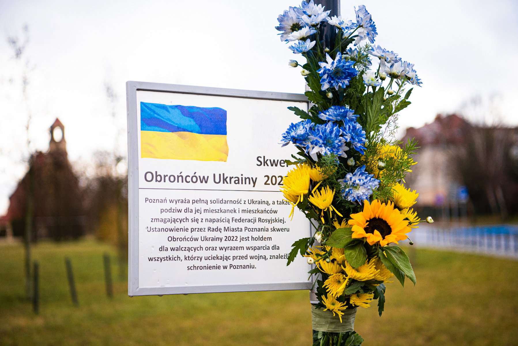 Tablica przymocowana do słupa ulicznego.