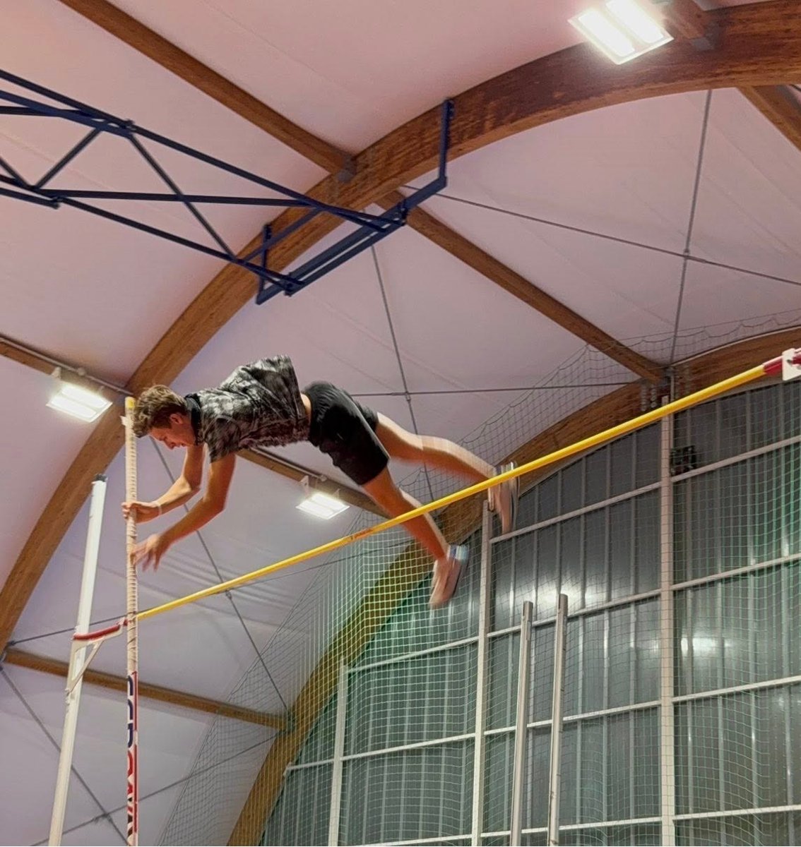 zawodnik skoku o tyczne podczas oddwania skoku, na zdjęciu znajduje się już nad drążkiem