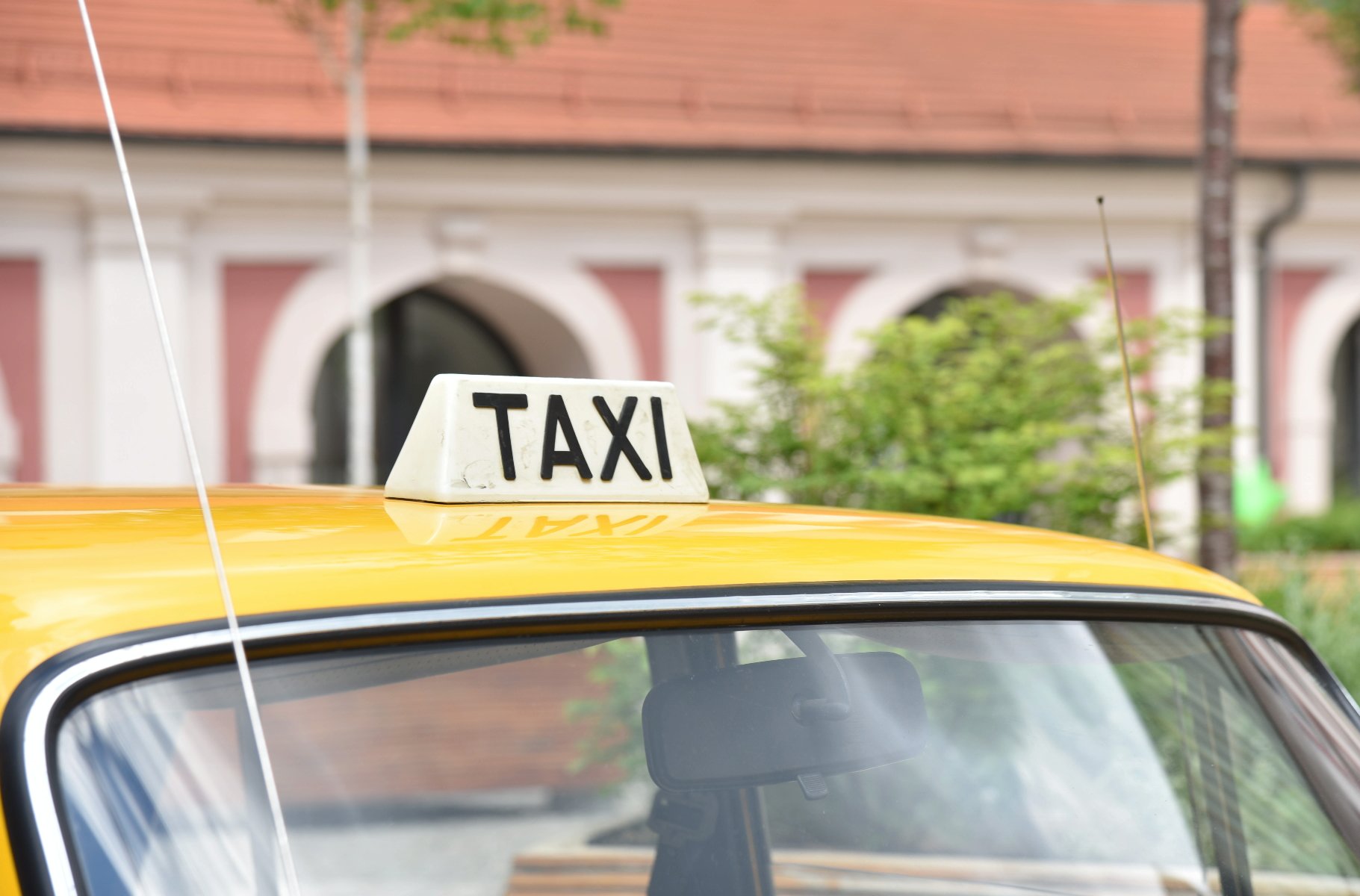 zdjęcie przedstawia dach żółtej taksówki z widoczną na nim lampą z napisem "taxi"