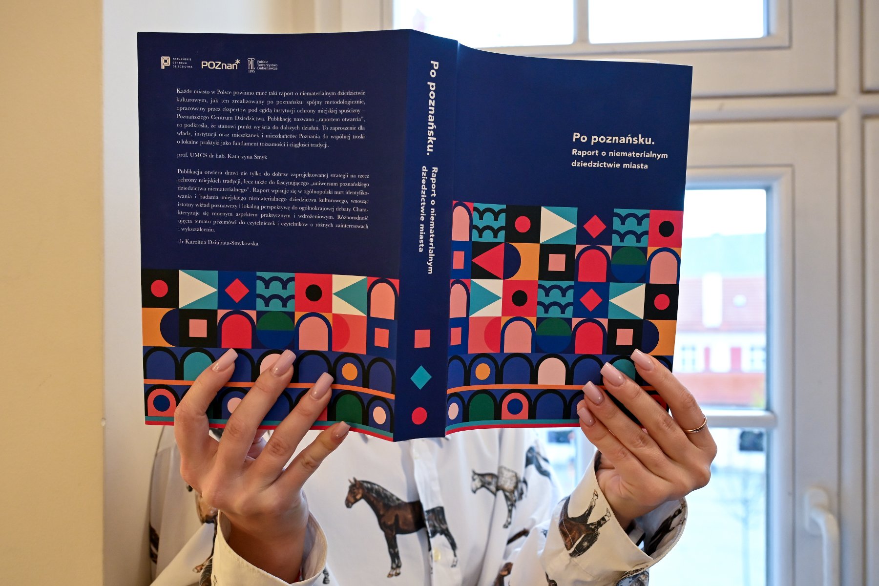 Zdjęcie przedstawia dziewczynę czytającą książkę. Nie widać jej twarzy.