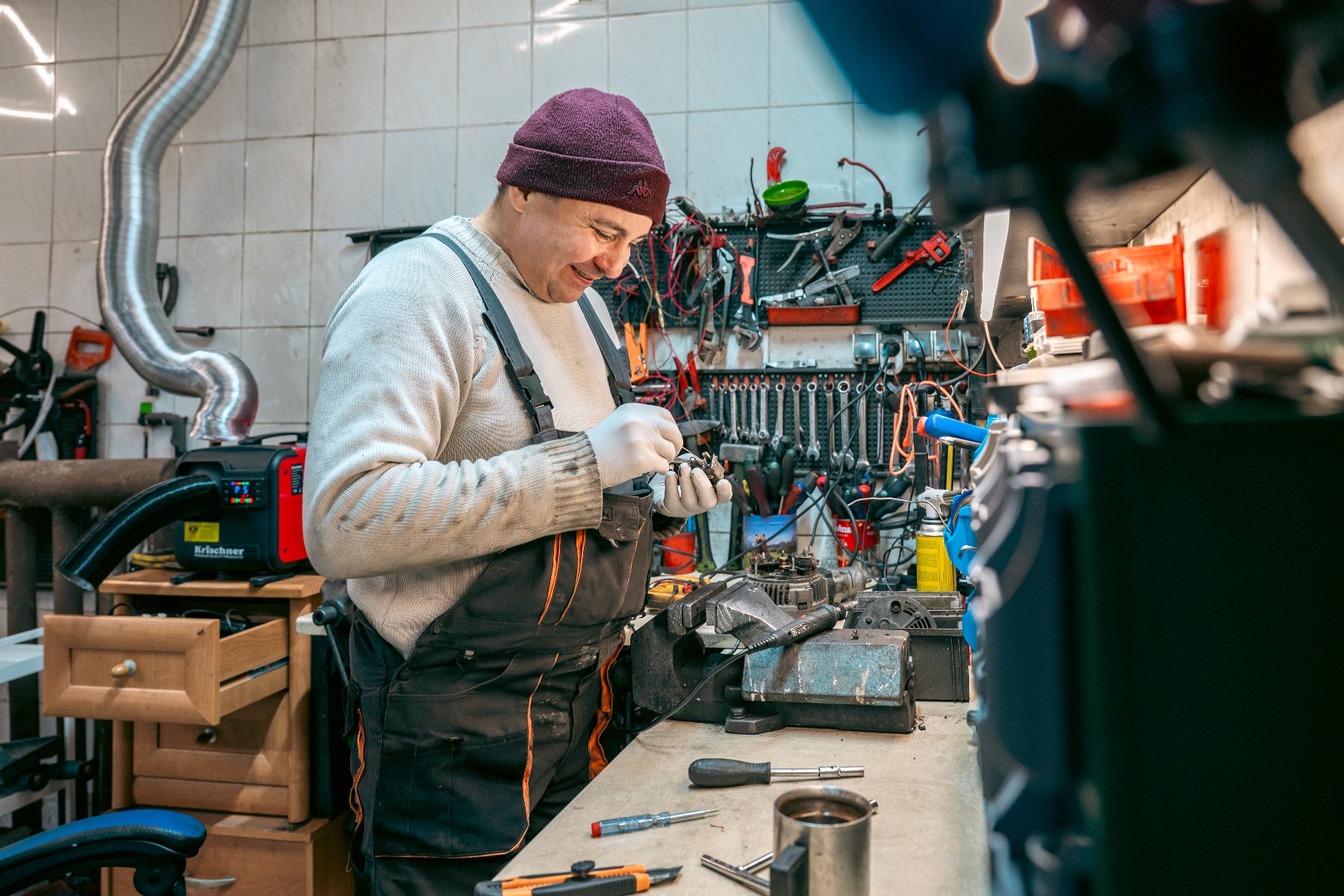 Zdjęcie przedstawia pracującą na maszynie do szycia w zakładzie krawieckim.