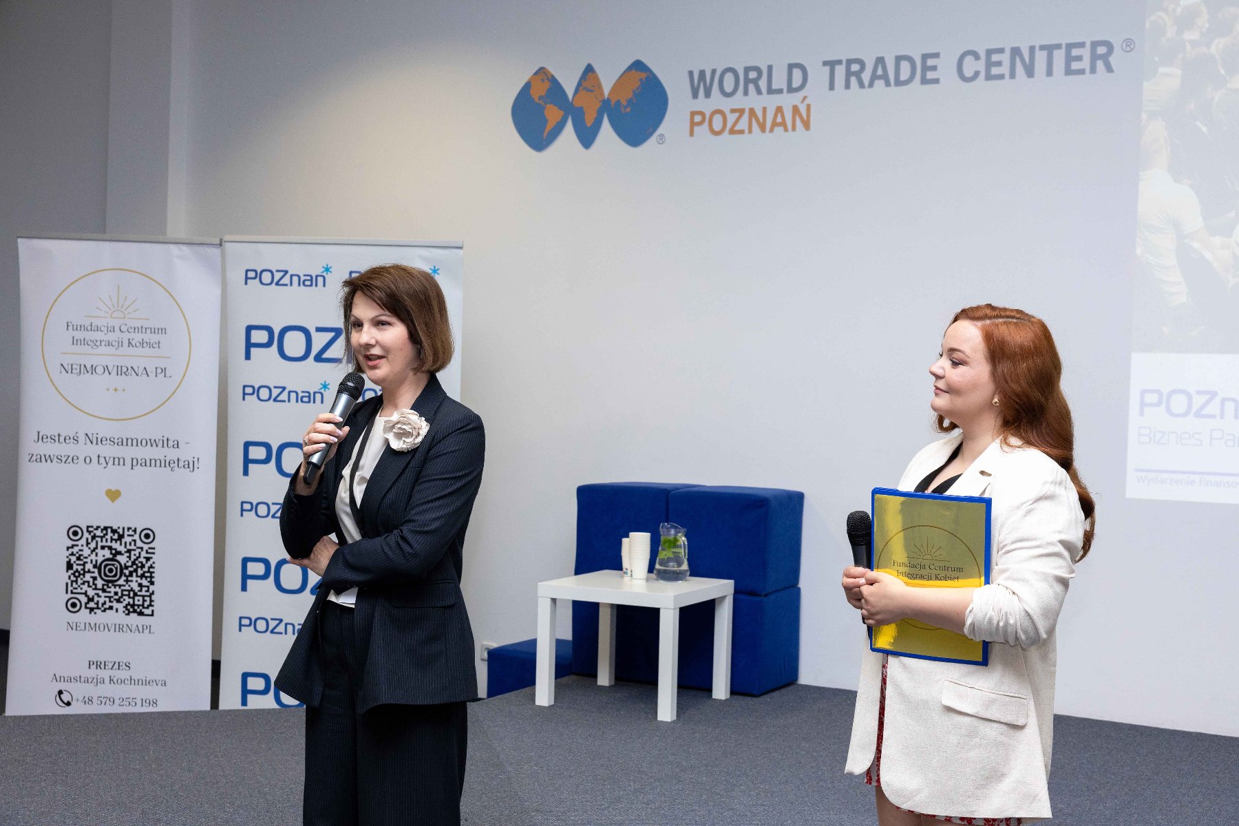 Podsumowanie konferencji Szansa na więcej - rozwój, biznes, przyszłość Zdjęcie przedstawiające dwie kobiety, Dyrektor WDGiR, Joannę Jajus oraz Prezeskę Fundacji Centrum Integracji Kobiet Nejmovirna PL, które witają uczestników konferencji