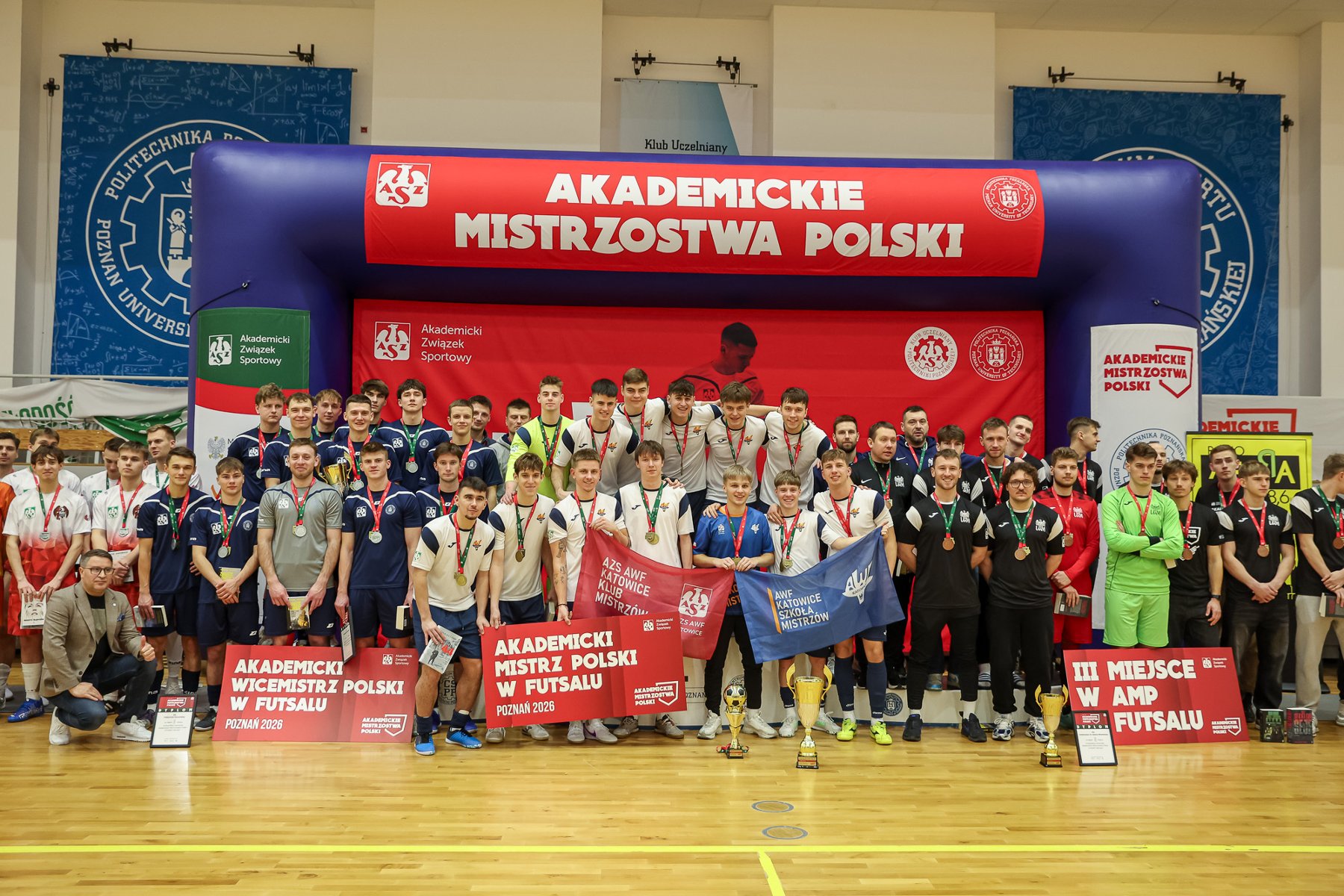 Akademickie Mistrzostwa Polski w futsalu mężczyzn, fot. Paweł Jaskółka - 3 najlepsze drużyny z medalami na tle bramy imprezy